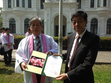 Mr Wakisaka and the Ambassador Hobo showing a photo of the flowers of the Sakura plants gifted.